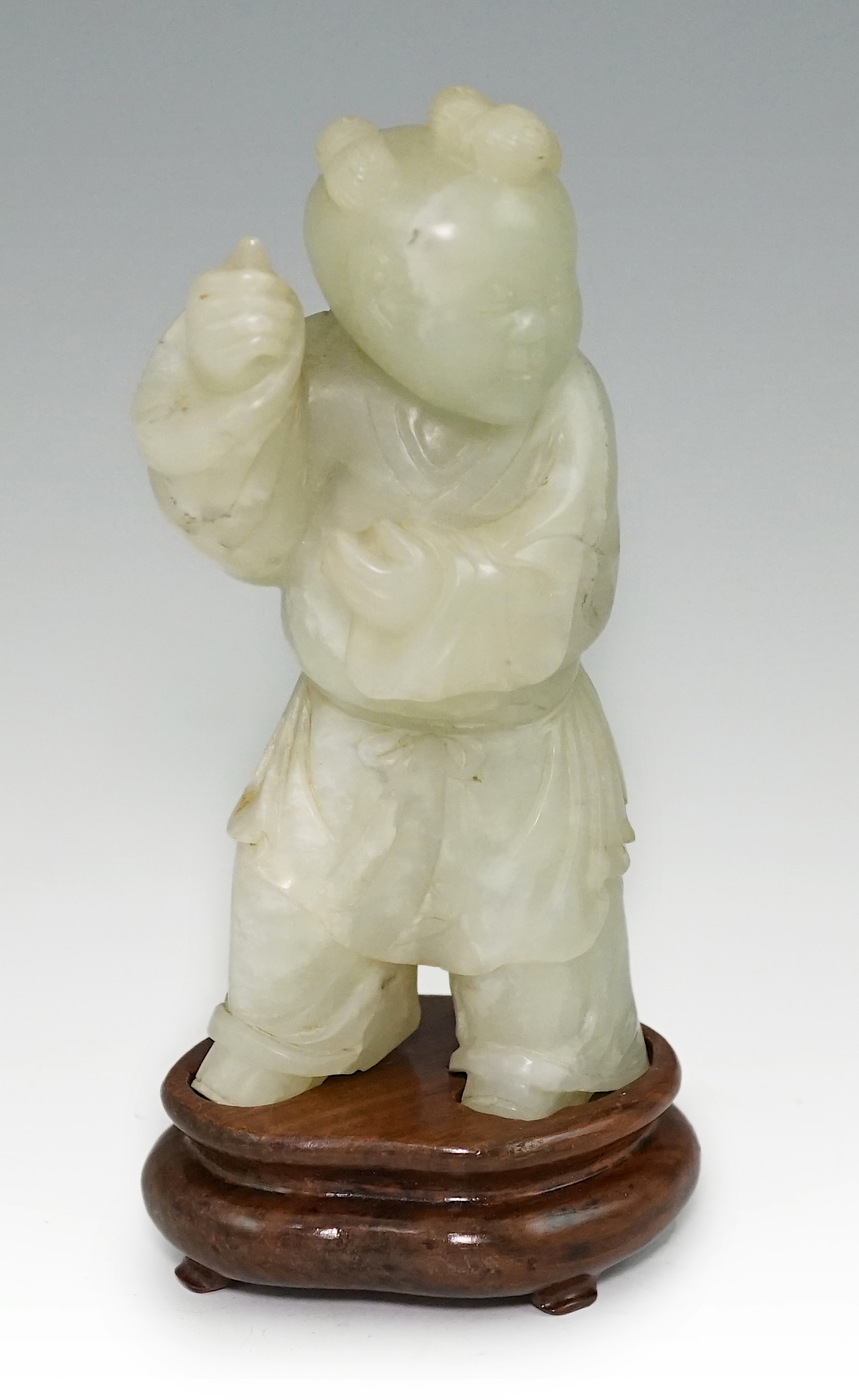 A Chinese pale celadon jade figure of a boy, 18th century